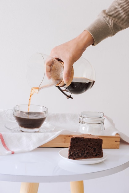 Brühen von Nel-Drip-Kaffee. Schritt für Schritt Kochanleitung. Kaffee ist fertig. Barista gießt gebrühten Kaffee in die Tasse