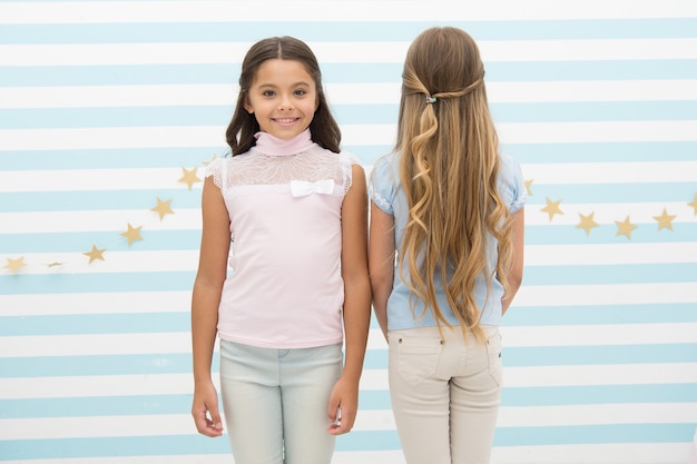 Brünett und blond. Friseursalon Dienstleistungen. Kleine Kinder mit langen Haaren. Kleine Mädchen mit langen lockigen Haaren. Gesundes Haar. Shampoo Conditioner Balsam und Maske. Curling-Styling. Schöne Locken.