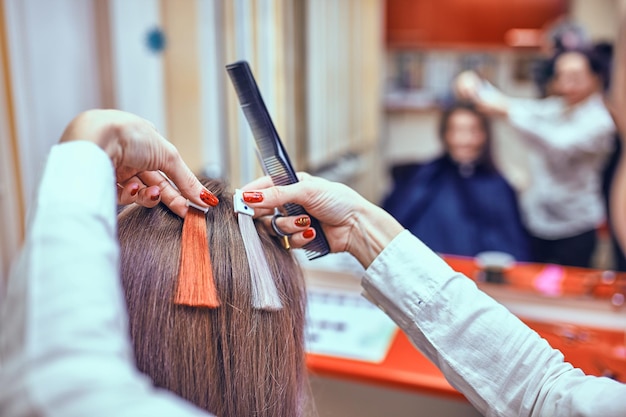 Brünette Frau, die ihr Haar im Schönheitssalon färbt