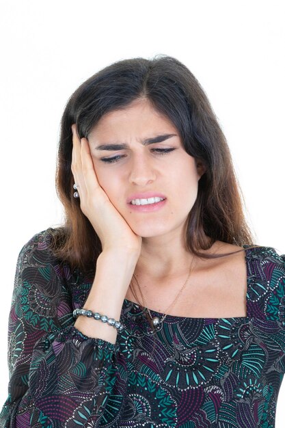 Brünette Frau in Schmerzen mit Kopfschmerzen Hand auf dem Kopf auf weißem Hintergrund