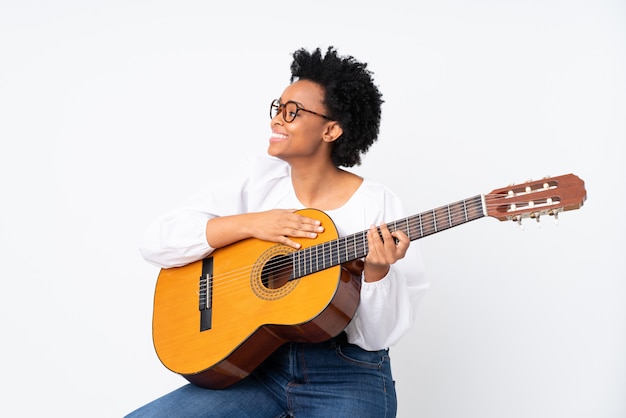 Brünette Frau mit einer Gitarre auf weißem Hintergrund