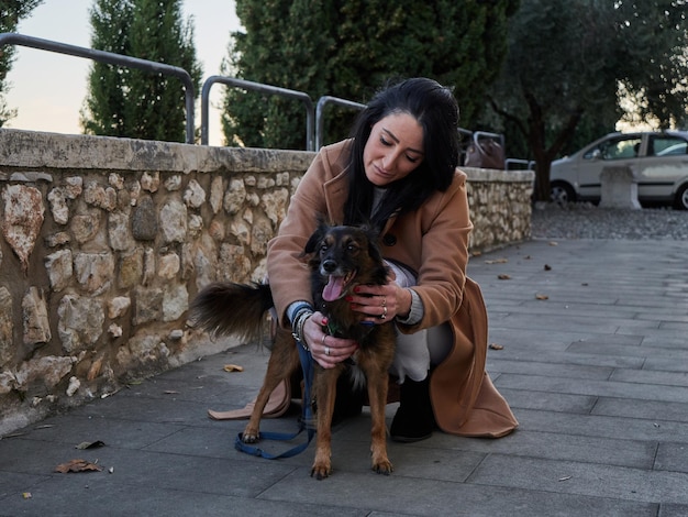 Brünette Frau spielt mit kleinem Hund