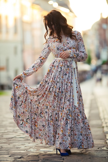 Brünette geht in einem schönen langen Kleid durch die Straßen von Lemberg