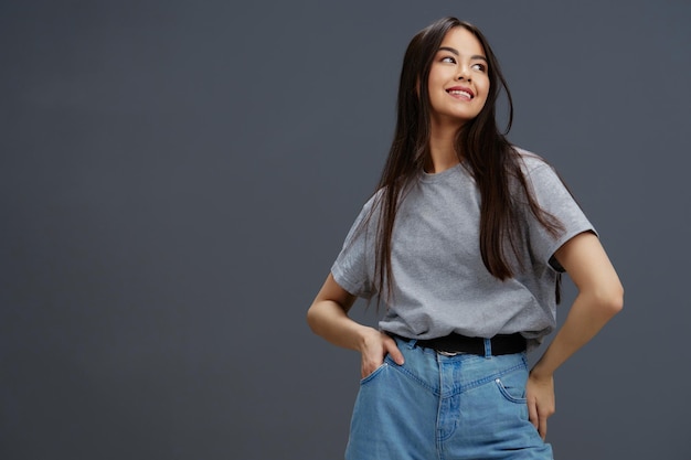 Brünette in T-Shirt und Jeans posiert Studiomodel im Jugendstil