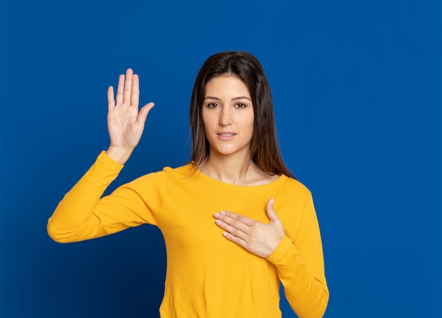 Brünette junge Frau, die über blaue Wand gestikuliert