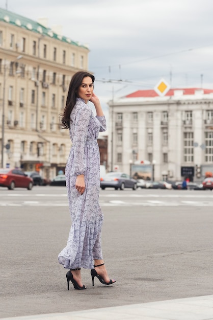Brünette Mädchen posiert an der Stadtstraße Hübsche schöne Geschäftsfrau im eleganten Kleid Stadthintergrund
