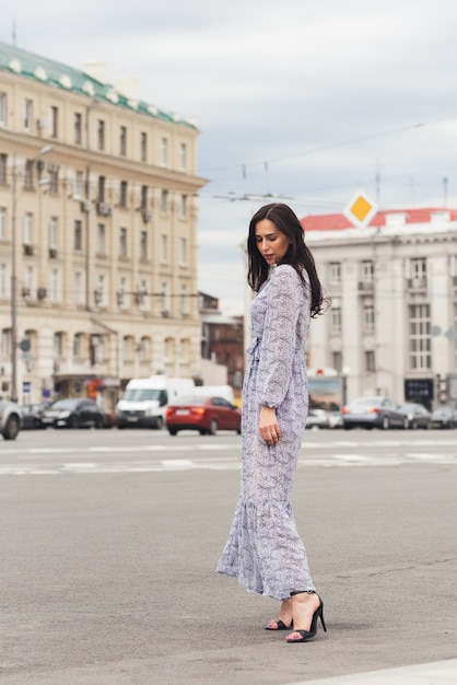 Brünette Mädchen posiert an der Stadtstraße Hübsche schöne Geschäftsfrau im eleganten Kleid Stadthintergrund