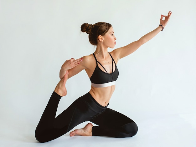 Brünette schöne fröhliche fitte Frau, die Yoga-Asanas macht Gesunder Lebensstil und Sportkonzept