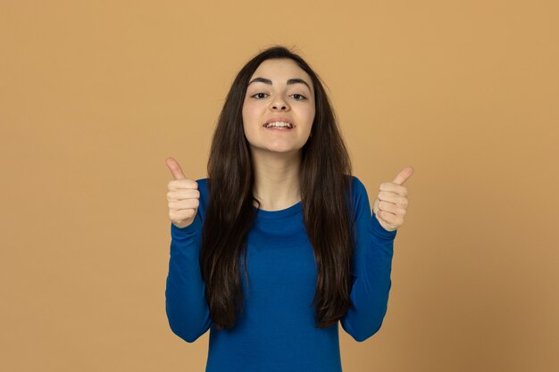 Brünettes junges Mädchen, das blaues Sweatshirt trägt