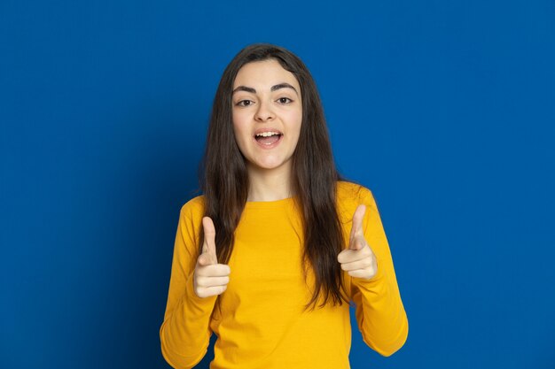 Brünettes junges Mädchen, das gelbes Sweatshirt trägt