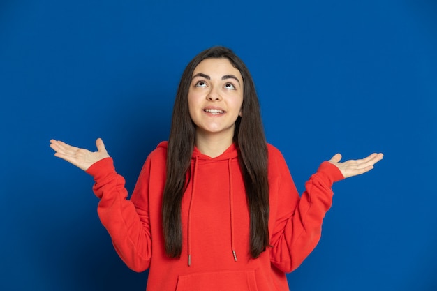 Brünettes junges Mädchen, das rotes Sweatshirt trägt