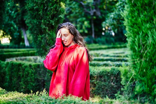 Brünettes Mädchen im Park bedeckt ihr Gesicht mit ihrer Hand