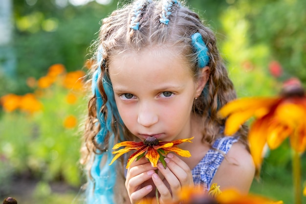 Brünettes mädchen mit langen haaren im garten geflochtenes haar mit blauem kanekalon-frisurenflechtenteenager-mädchen mit modischen blauen zöpfenkleines mädchen mit zöpfen