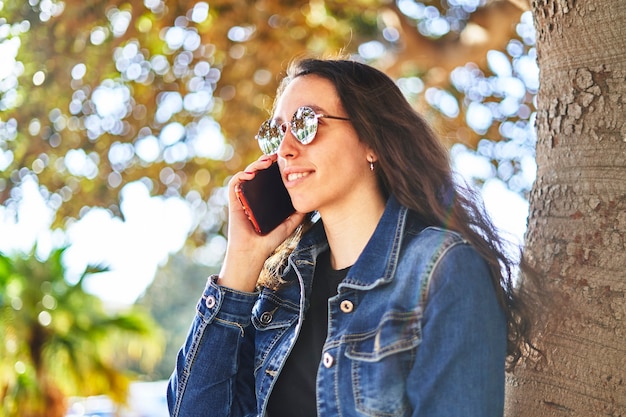 Brünettes Mädchen mit Sonnenbrille telefoniert