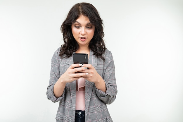 Brünettes Mädchen surft im Internet und hält ein Telefon in den Händen