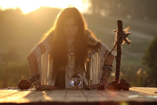 Bruja con bola de cristal al atardecer