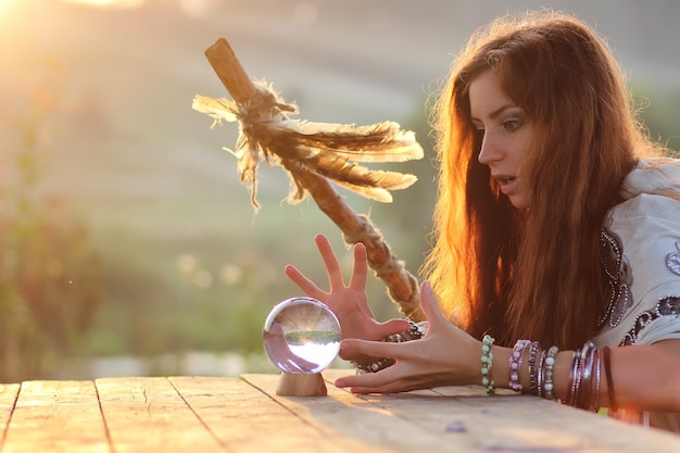 Foto bruja con bola de cristal al atardecer