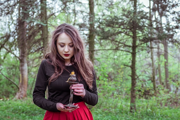 Bruja en el bosque con una vela