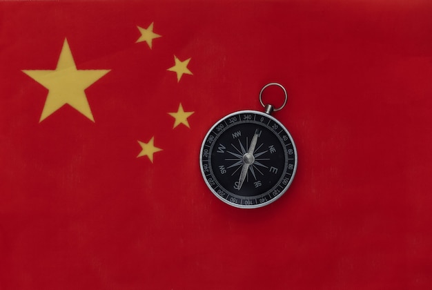 Brújula en la bandera de China de cerca. Vista superior