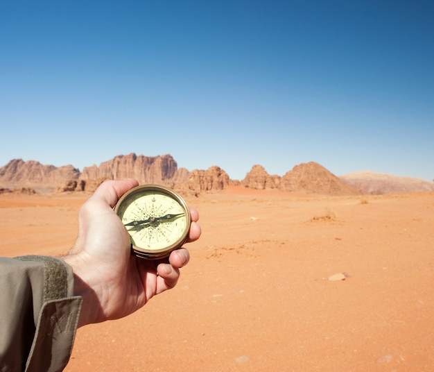 brújula de mano masculina en el desierto