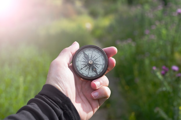 Una brújula en una mano en la naturaleza