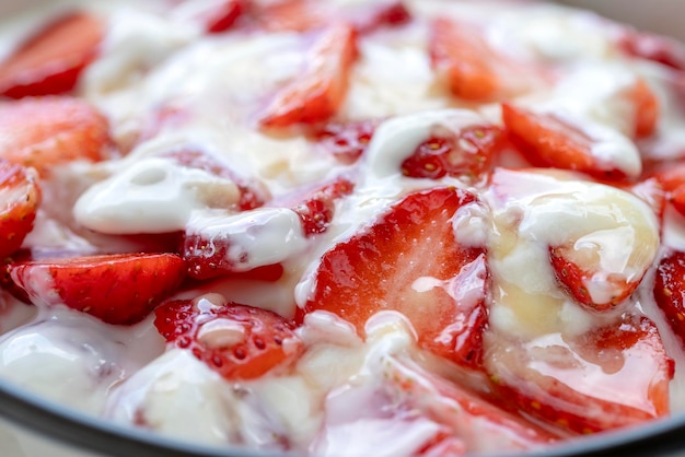 Brulee aus roten Erdbeeren und weißem Joghurt Fruchtdessert zum Frühstück mit Keilen aus perfekt reifen Erdbeeren der Saison in der Nähe