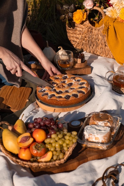 Un brunch festivo de otoño entre los árboles amarillos con calabazas, un café y un pastel, Acción de Gracias o una cena familiar en el patio trasero. Nadie