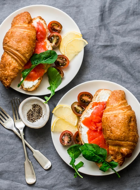 Brunch oder Frühstückstisch Croissants mit Frischkäse und Räucherlachs und Kirschtomaten Leckerer ausgewogener Frühstücksbrunch