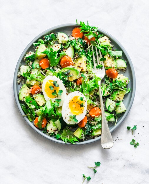 Brunch de Pascua huevos de quinua aguacate pepino ensalada de zanahoria sobre fondo claro vista superior