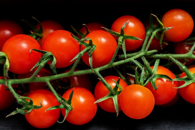 Brunch de tomates cherry frescos en la pared negra. Comida sana, vegetales maduros