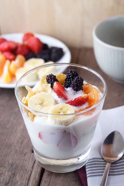 Brunch: vaso de yogur casero con cereales, fresa, plátano, mora, naranja y muesli. Desayuno saludable.