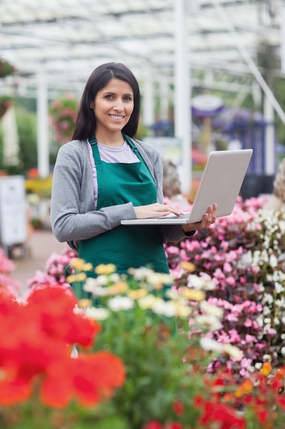 Brunette, der auf dem Laptop in der Gartenmitte schreibt