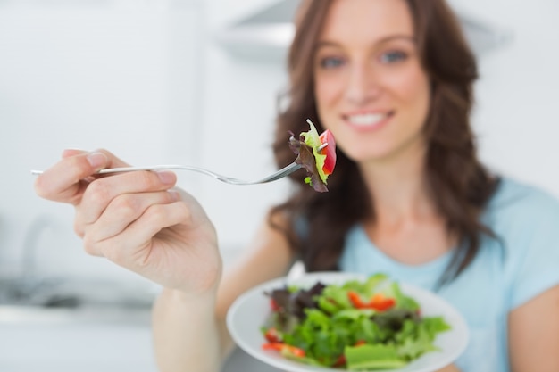 Brunette, der gesunden Salat anbietet