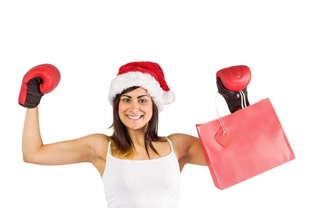 Brunette festivo em luvas de boxe segurando sacolas de compras
