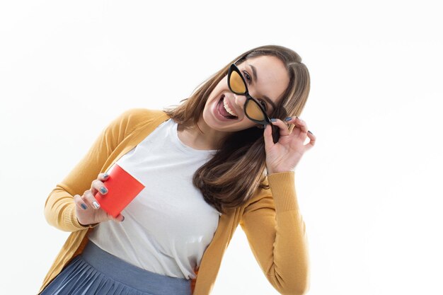 Brunette in einem gelben Pullover trinkt Kaffee aus einem roten CupWhite isolierten Hintergrund Kaffee