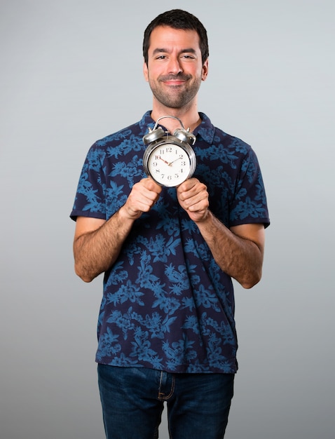 Brunette Mann mit Vintage Uhr auf grauem Hintergrund