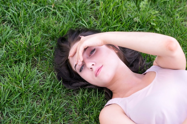 Brunettefrau, die draußen auf Gras stillsteht