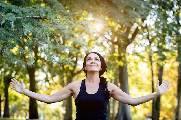 Brunettefrau, die Yoga in einem Park tut