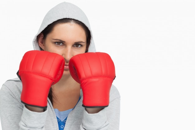 Brunettefrau in tragenden Boxhandschuhen des Sweatshirts