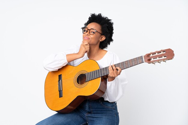 Brunettefrau mit einer Gitarre über weißem Hintergrund