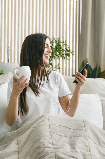 Brunettemädchen trinkt Kaffee und hört ihre Lieblingsmusik