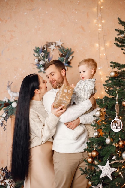 Brunettemuttervater und kleiner Sohn, die nahe Weihnachtsbaum stehen