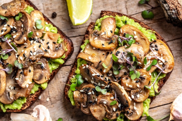 Bruschetta abacate, cogumelos e sanduíche microgreen de grãos inteiros