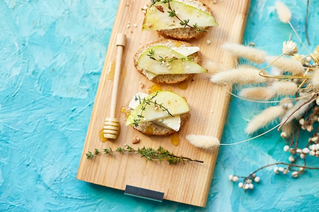 Bruschetta-Antipasti mit Blauschimmelkäse und Birne auf Holzbrett