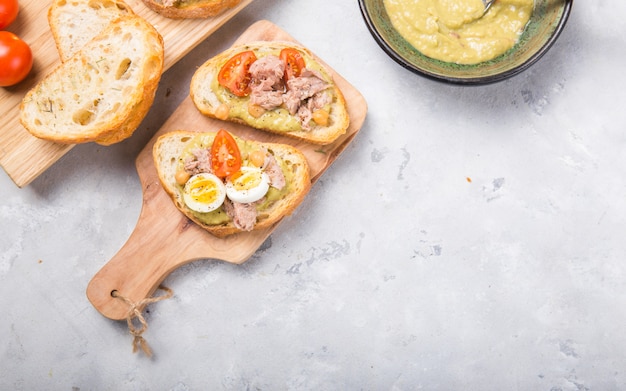 Bruschetta con atún, tomate, huevo y aguacate.