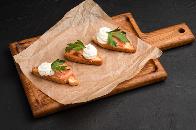 Bruschetta bruschetta diferente con diferentes rellenos sobre un fondo negro