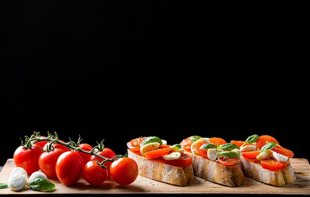 Foto bruschetta caprese manjericão fresco folhas tomates maduros aromáticos e mussarela italiana na bruscheta regada com azeite e polvilhada com pimenta e ervas