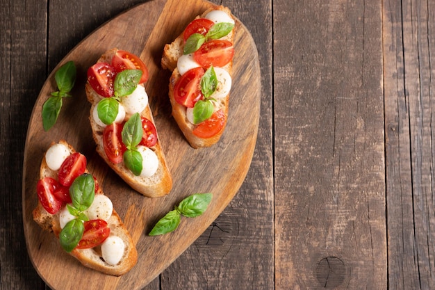 Bruschetta caprese recién hecha con tomate, albahaca y queso. Tapas italianas, antipasti con verduras, él