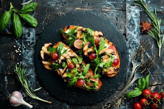 Bruschetta con champiñones, rúcula, uvas y queso feta Espacio libre para su texto Vista superior