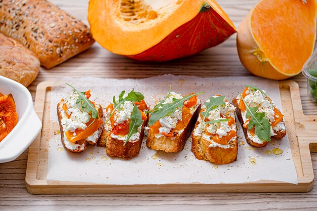 Bruschetta de chapata a la parrilla con calabaza al horno, rúcula feta y especias. bocadillo saludable de calabaza al horno de otoño